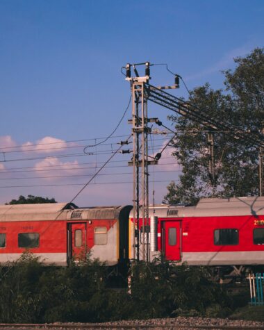 red and white train on rail under blue sky during daytime