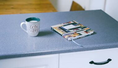 gray and white ceramic mug beside multicolored covered book