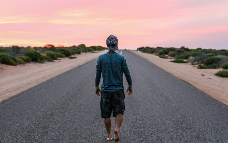 man walking on gray concrete road
