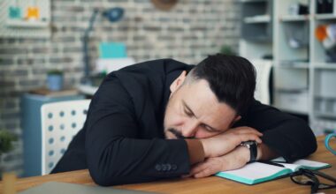 a man leaning his head on his desk