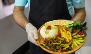 person holding brown round plate with burger