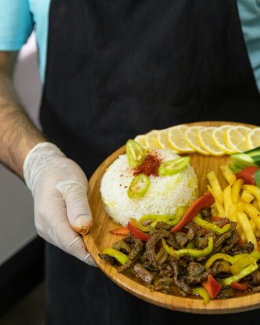 person holding brown round plate with burger