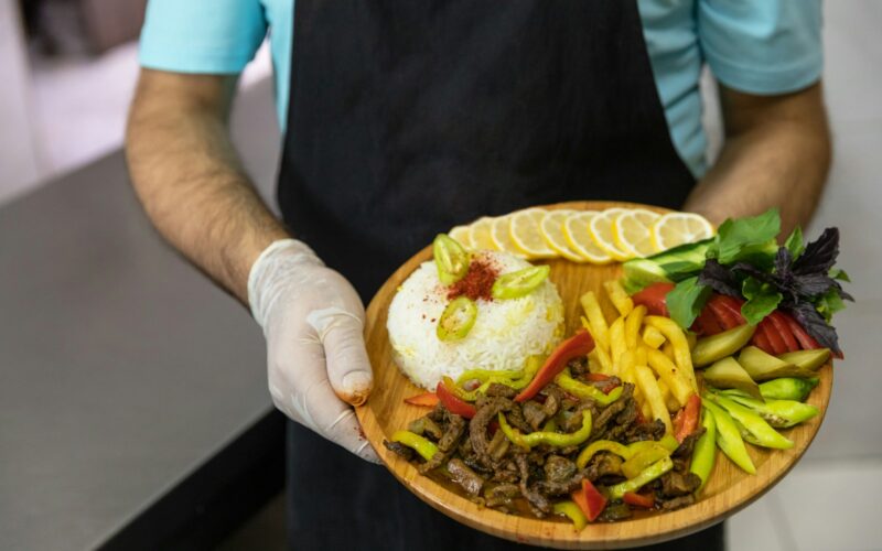 person holding brown round plate with burger