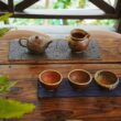 A wooden table topped with three cups of coffee