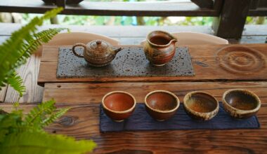 A wooden table topped with three cups of coffee