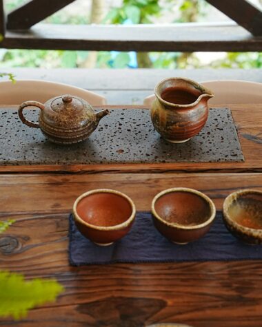 A wooden table topped with three cups of coffee