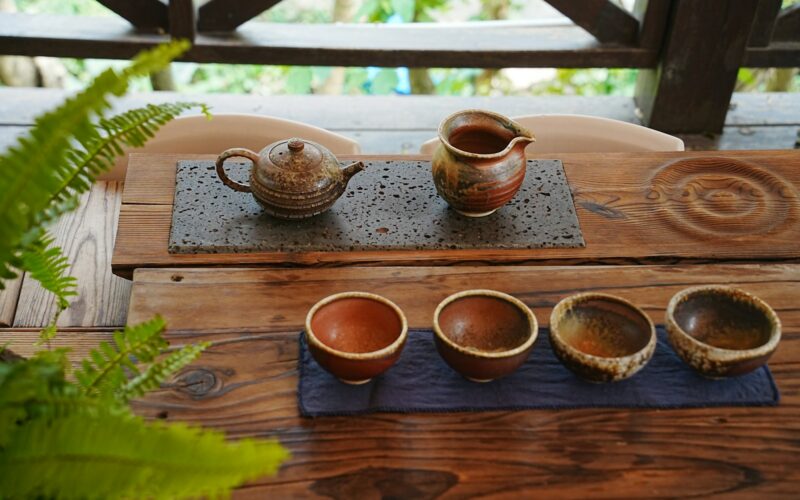 A wooden table topped with three cups of coffee